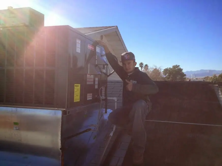 HVAC technician performing Air Duct Repair on a rooftop unit in Coventry